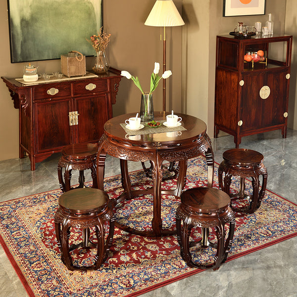 Close-up of a concave rosewood round table with intricate leg carvings