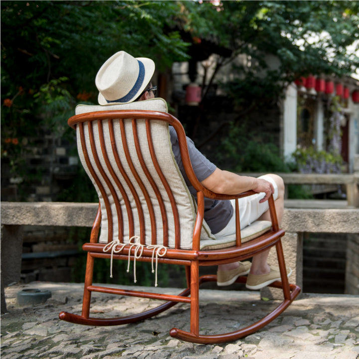 Large rosewood rocking chair with a comfortable backrest and armrests.