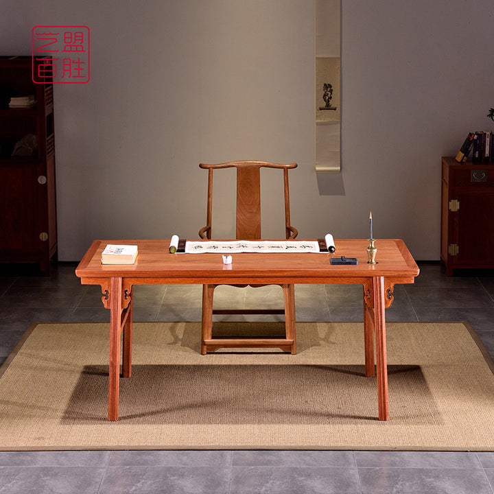 Front view of a Pterocarpus macrocarpus desk with a scroll and candle holder