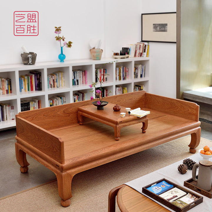 A Pterocarpus macrocarpus sofa bed with round ball feet, featuring a wooden tea table on top.