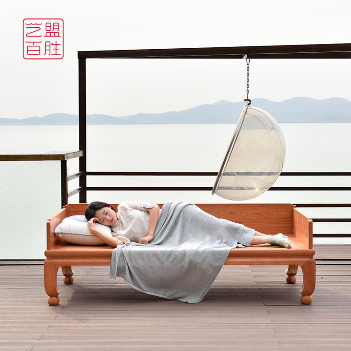 Elegant wooden sofa bed made from Pterocarpus macrocarpus, displaying a natural finish and round ball feet.