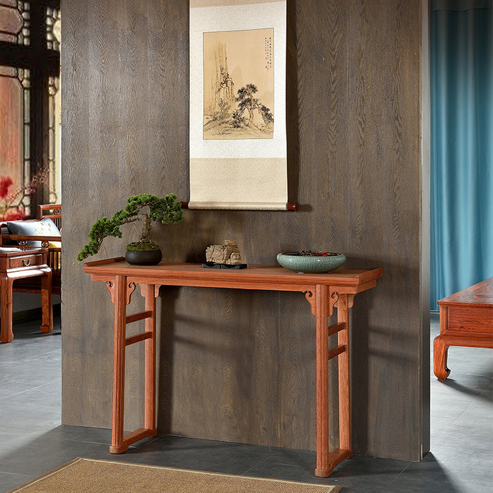 A Pterocarpus macrocarpus console table with elegant decorations.